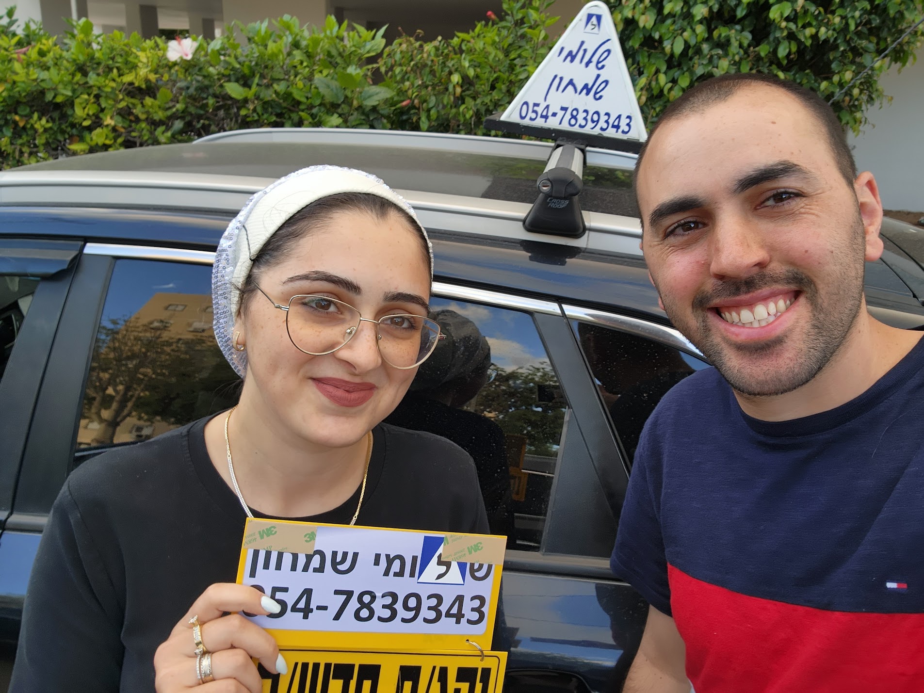 תלמיד עם שלומי שמחון, מורה נהיגה, מחזיק שלט "נהג חדש" לאחר המבחן – תמונה 27