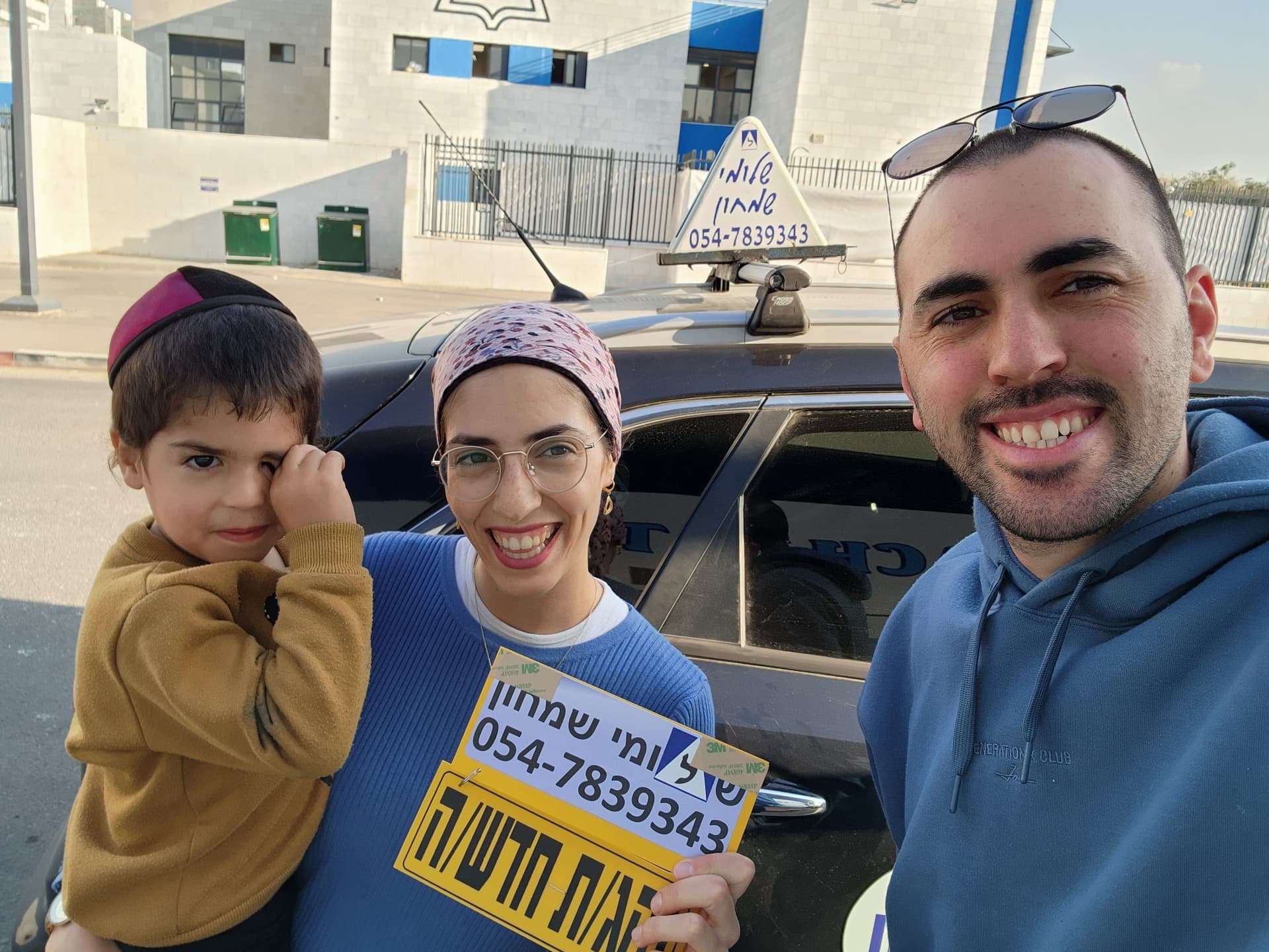תלמיד עם שלומי שמחון, מורה נהיגה, מחזיק שלט "נהג חדש" לאחר המבחן – תמונה 54