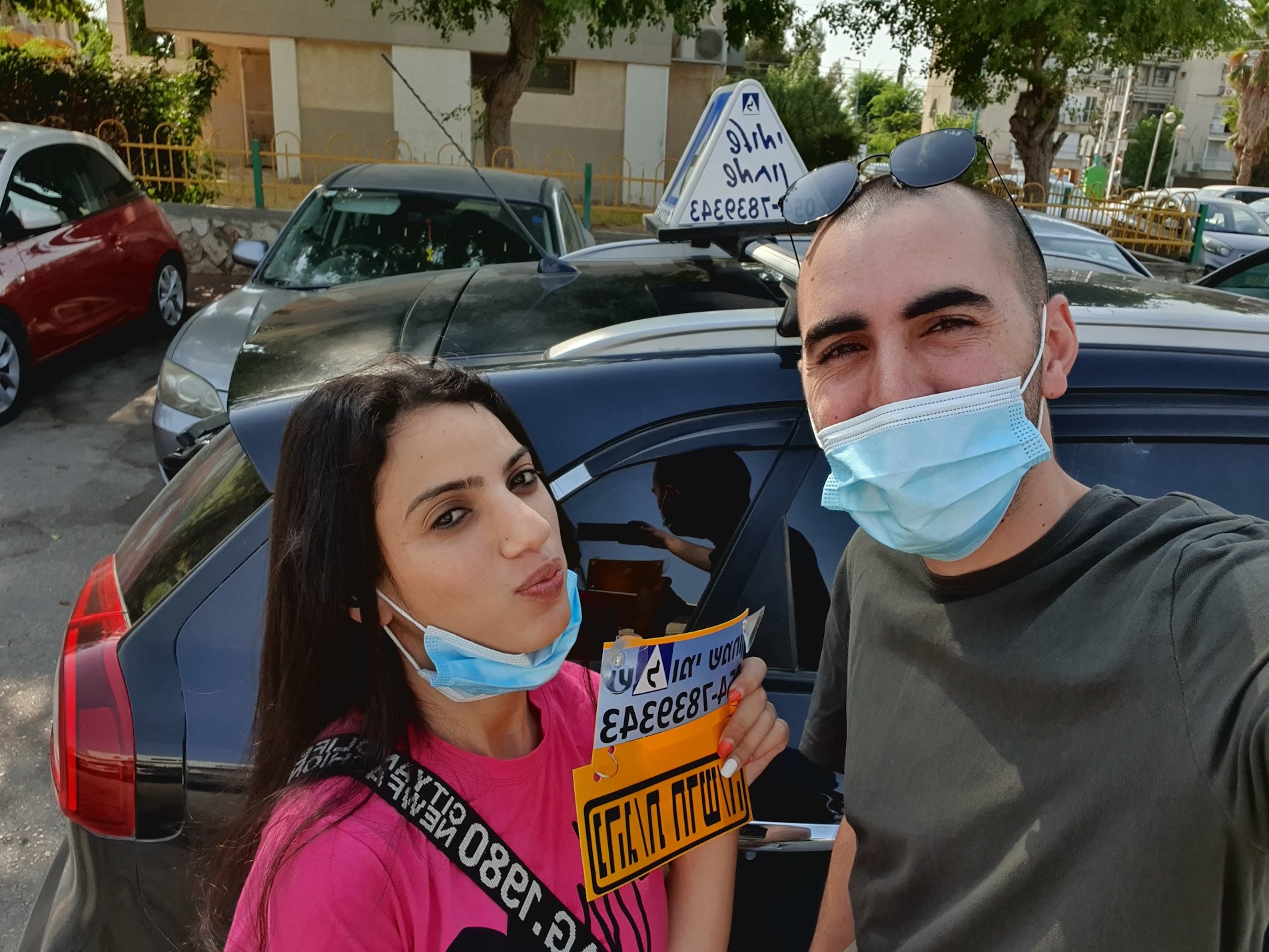 תלמיד עם שלומי שמחון, מורה נהיגה, מחזיק שלט "נהג חדש" לאחר המבחן – תמונה 64